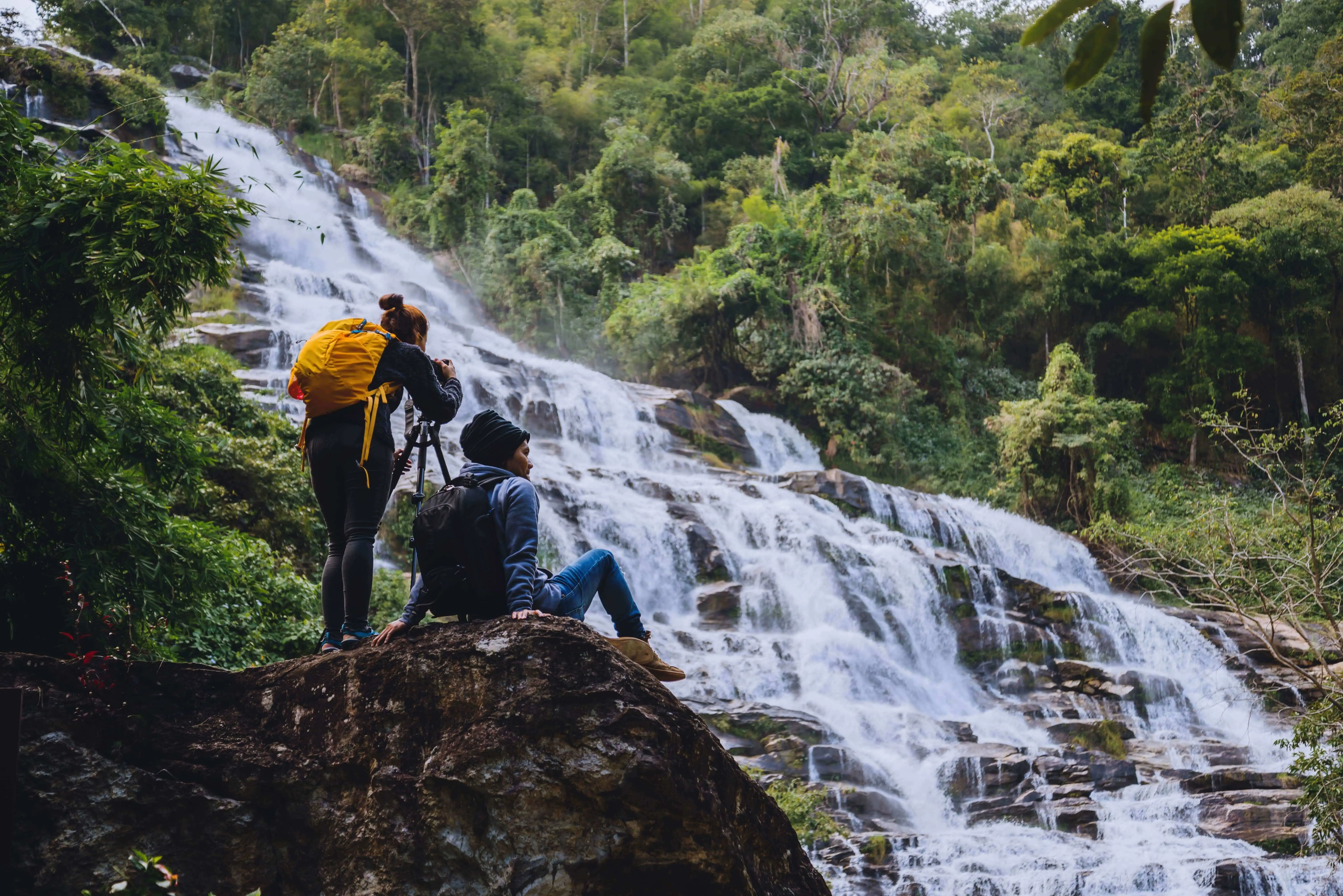 couple photographing nature close to a waterfall