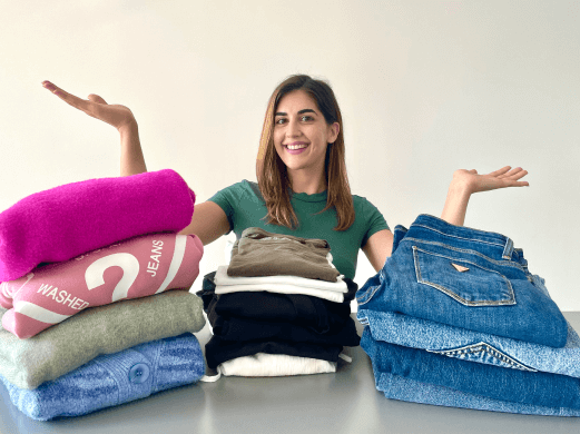 Moincoins content creator Rena with two piles of tested eco-friendly clothes on the table