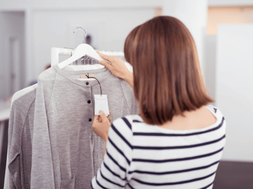 A woman looking at a label of a shirt
