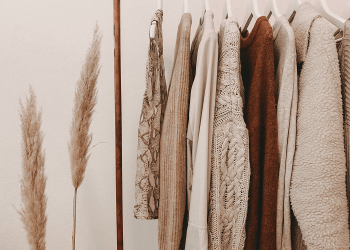 Clothing rack with women clothes in beige colors 